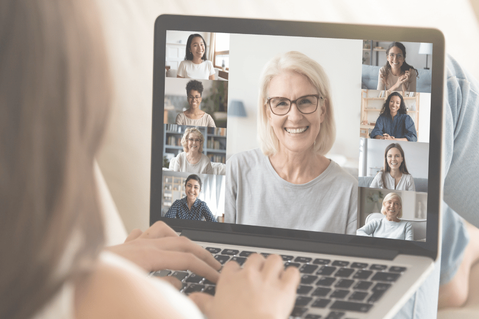 Bakhode til dame som sitter foran laptop med skjerm som viser et digitalt møte